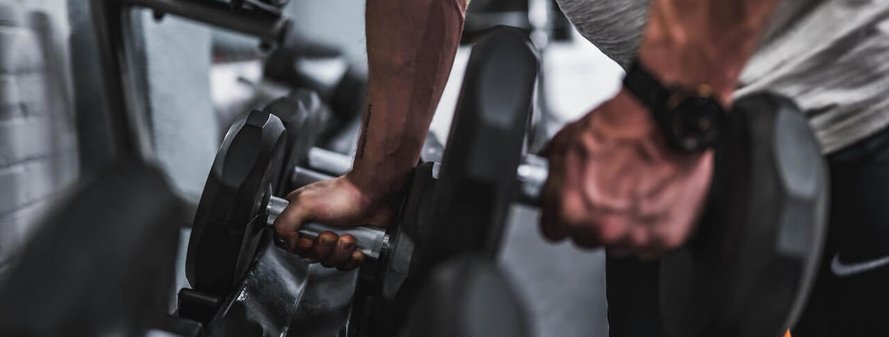 man gripping weights ready to work out while dreaming of masturbating when he gets home from the gym